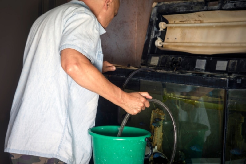 Man cleaning a dirty fish tank