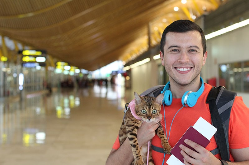 Handsome man traveling with his cat