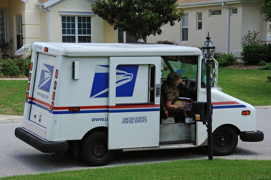 Postal Worker Delivering Packages To A Home